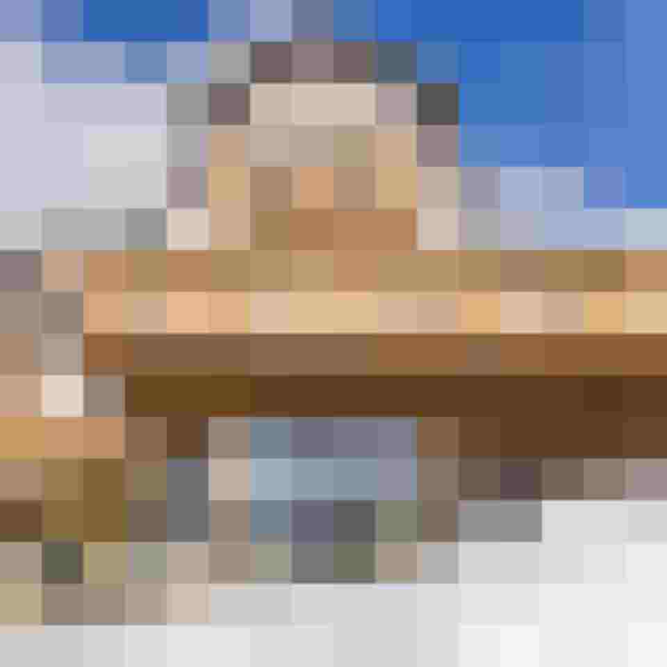 Hotel im Lungau mit Holzfassade und Balkon im Winter vor blauem Himmel