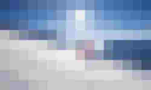 Skifahrer auf sonniger Piste in verschneiter Berglandschaft